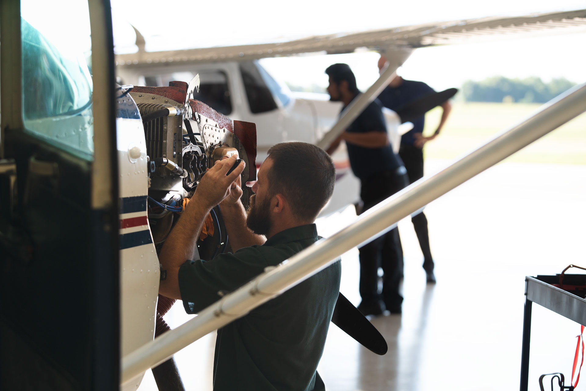 Image of student working on a plane in a hangar. It is used on the flight training program page.
